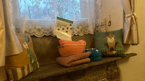 Un banco de piedra con artículos para mascotas, un letrero de bienvenida y almohadones decorativos.