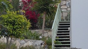 Una pared de piedra con una escalera que sube a un balcón.