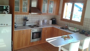 Una cocina con armarios de madera, horno empotrado, microondas y ventana con vistas.
