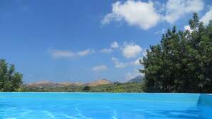 Una piscina azul cristalina con vista a una montaña al fondo.