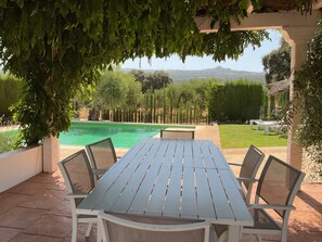An outdoor patio with a pool, surrounded by greenery and a view of distant hills. - RURAL HOUSE WITH PRIVATE POOL 4 KM FROM ROUND Wifi                         (Ronda)