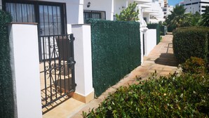 A residential building with a gated entrance, a pathway, and well-maintained greenery.