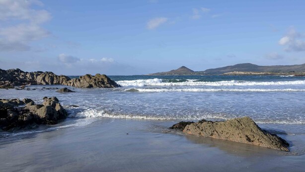 A rocky beach with waves, a clear sky, and distant mountains. - Beachside holiday home in stunning location overlooking the wild Atlantic way. (Castlecove)