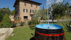 Un bâtiment en pierre avec une fontaine au premier plan.