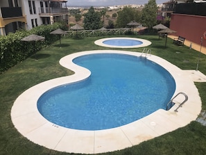 Enjoy a refreshing swim in our pool surrounded by a lush lawn and a wooden fence.