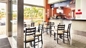 Ein Café mit Außenbereich, einer Backsteinmauer und einer Theke mit Speisekarte.