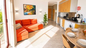 A modern apartment with a living area, kitchen, and dining space.