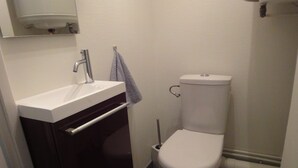 Ein Badezimmer mit Toilette, Waschbecken mit Handtuch und Spiegel darüber.