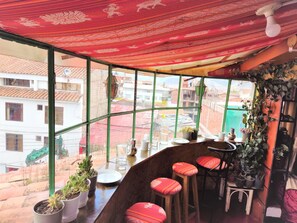 Sit and enjoy the view from this enclosed seating area with a wooden bench and potted plants.