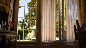 A room with a large window, a door, and a chair.