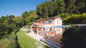 Une maison avec un patio, un espace salon extérieur et une piscine.