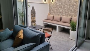 A modern living room with a sofa, a dining table, and a decorative Buddha statue.