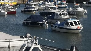 A marina with various boats docked, including a white boat named 'OSPREY' with a cabin and outboard motor. - Pebbles Superb Apartment/Woodland & Sea View/Short Walk Beach/Free Parking &WiFi (Saundersfoot)
