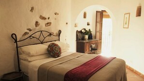 Una camera da letto con un letto, un comodino, una cassettiera e una parete decorativa.