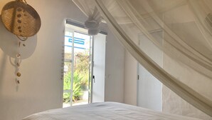 A bedroom with a bed, a hanging basket, and a view of the outdoors through a door. - Chill out and relax in true Portuguese style  (Santa Barbara de Nexe)