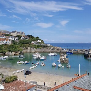 A coastal town with a harbor filled with boats, a sandy beach, and houses on a hillside. - Amazing views of Fistral Beach with secure parking for 2 vehicles (Newquay)