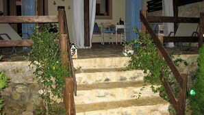 A stone staircase with wooden railings leading to a room with a table and chairs. - Villa Ostria, Lefkogia Cottage on a 20.000 sq.m.farm! Only 1 km from the beach.  (Rethymno)