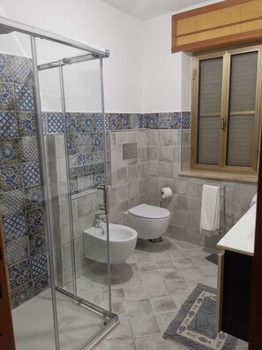 Tina con regadera, secadora de cabello, bidet, papel de baño 