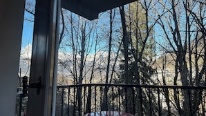 A balcony with a metal railing and a red table. - Winter/Summer holidays in St Gervais Le Bains Sleeps 4 (Saint-Gervais-Les-Bains)