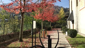 A pathway leading to a building with a traditional architectural style, surrounded by trees with autumn leaves. - Winter/Summer holidays in St Gervais Le Bains Sleeps 4 (Saint-Gervais-Les-Bains)