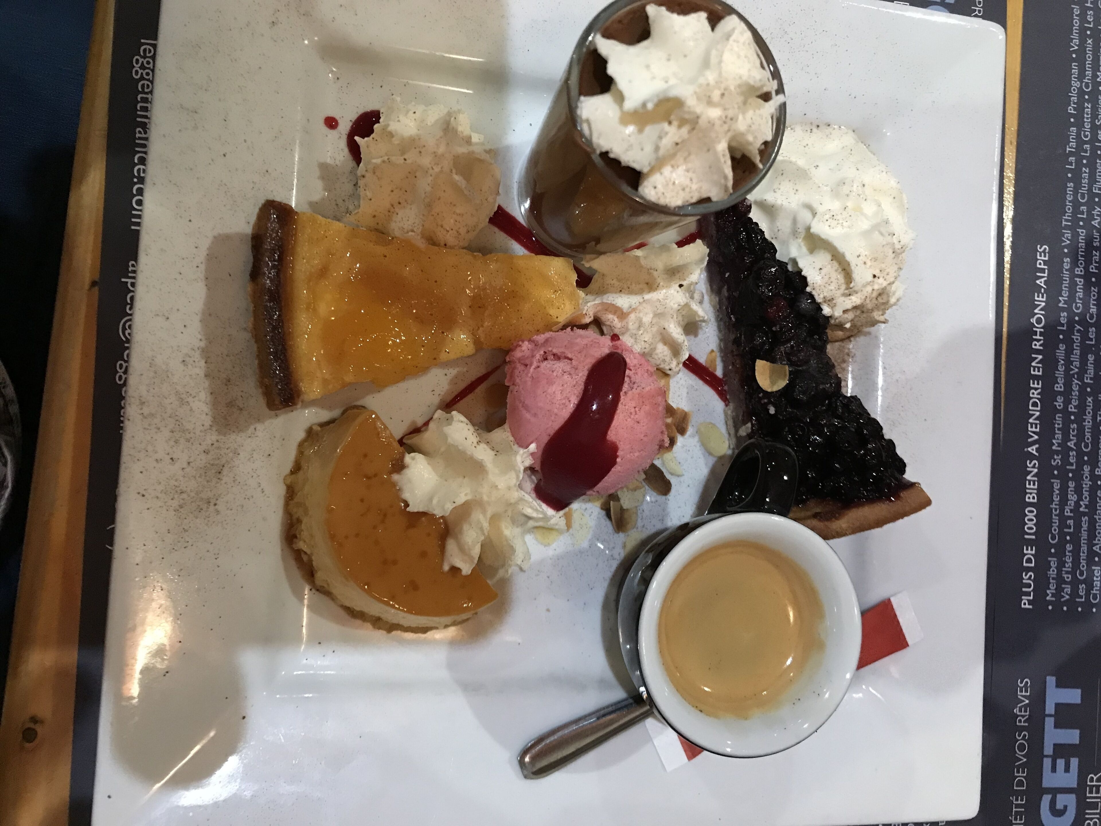 A dessert tray with various sweets and a cup of coffee.