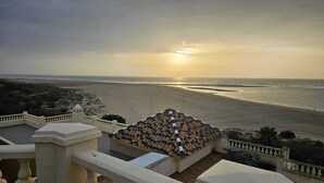 A beach view from a balcony with a tiled roof and a railing. - Luxury beach penthouse apartment in ISLA CANELA. The best views front line beach (URBANIZACION LOS CISNES)