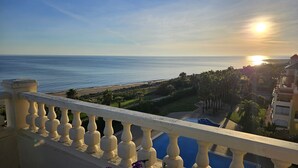 A balcony with a view of the sea and a swimming pool. - Luxury beach penthouse apartment in ISLA CANELA. The best views front line beach (URBANIZACION LOS CISNES)