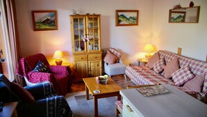 A cozy living room with a wooden cabinet, a sofa, a chair, and a table with a bowl of fruit. - Very well appointed Apartment in Chatel , very convenient for shops ,restaurants (Châtel)