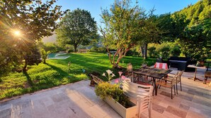 Une terrasse avec des meubles d’extérieur, une petite piscine et une pelouse bien entretenue.
