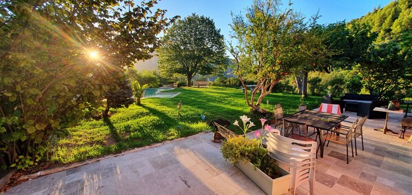 Un patio con mobiliario exterior, una piscina pequeña y un césped bien cuidado.