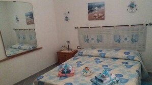 A bedroom with a bed, a nightstand, a mirror, and wall decorations. - Peaceful Holiday Home. (Posada)