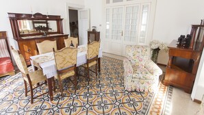 A dining area with a wooden table and chairs, a floral sofa, and a patterned floor. - ** FAMILY APARTMENT IN TRASTEVERE ** 220sqm -6 bedrooms in the center of ROME!!! (Roma)