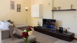 Ein Wohnzimmer mit einer Couch, einem Fernseher und Dekorationselementen.