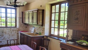 A kitchen with a dining table, chairs, cabinets, and a window with a view. - mansion - Fournels (Fournels)