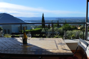 En balkon med et bord, en vinflaske og to glas.