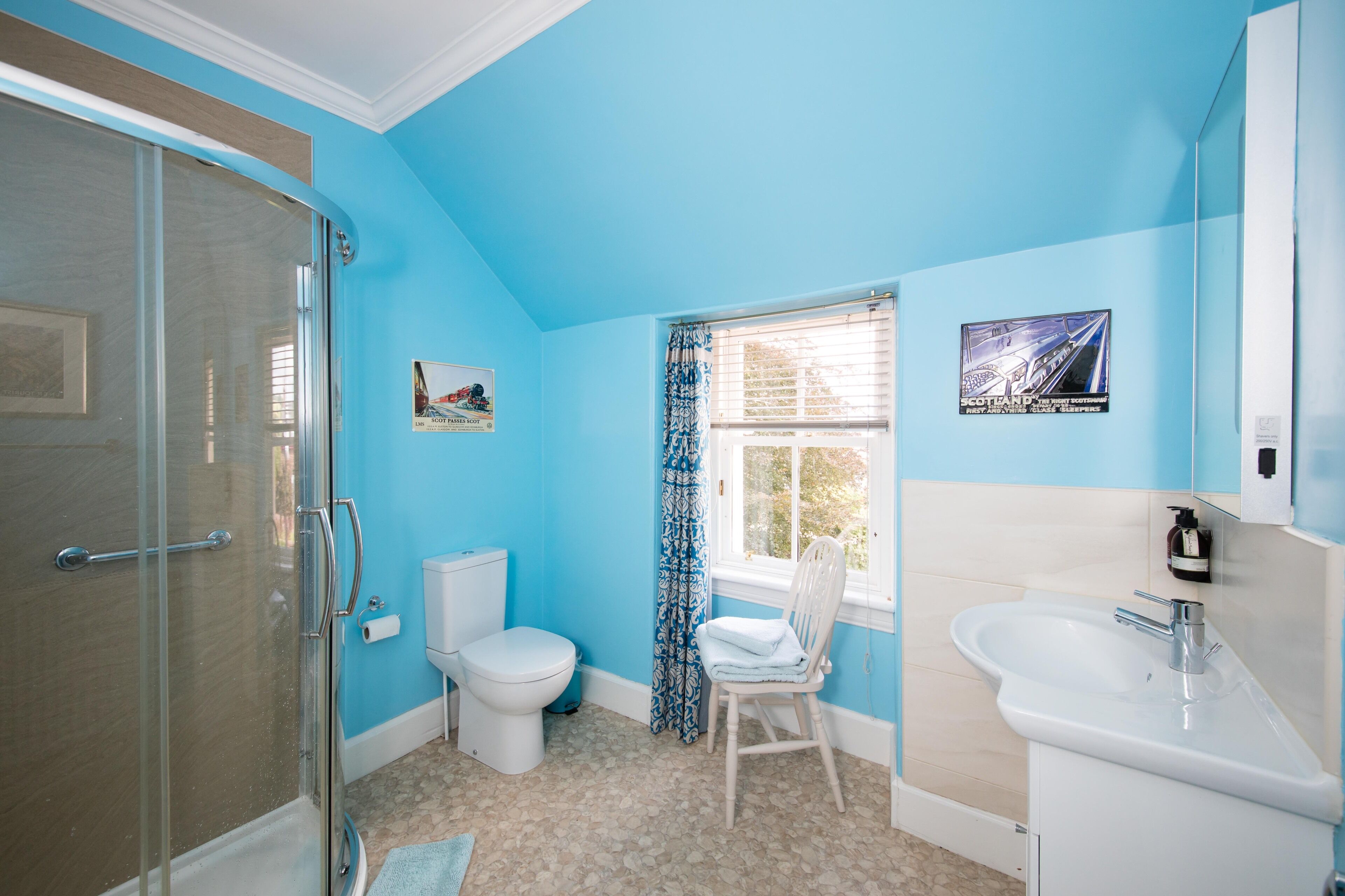 A bathroom with a shower, toilet, and sink.