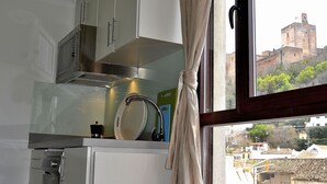 A kitchen with a modern design, a window with curtains, and a view of a historic building.