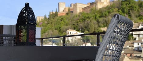 Ein Balkon mit Blick auf eine historische Burg und üppiges Grün.