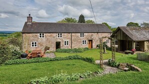A stone house with a garden, a wooden table, and a barbecue. - Croft Meadows Farm -  5 bedroom, dog friendly cottage in rural Staffordshire  (Leek)