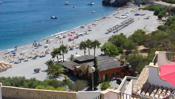 A beach with numerous boats, umbrellas, and people. - Excellent house facing the sea in urbanization with community pool (Almuñécar)