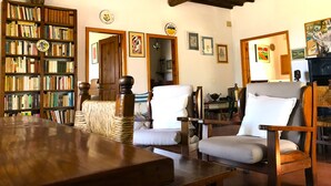 A cozy living room with a wooden table, two armchairs, a bookshelf, and a fireplace. - House / Villa - Monte San Savino (Monte San Savino)
