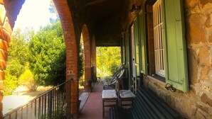 A covered outdoor area with brick arches, green shutters, and a bench. - House / Villa - Monte San Savino (Monte San Savino)