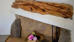 A rustic bathroom with a stone sink, a wooden shelf, and a decorative arrangement of flowers. - Sos Giajos Rural house (Nulvi)