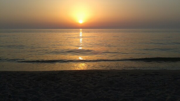 A beach scene with the sun setting over the water. - Sos Giajos Rural house (Nulvi)
