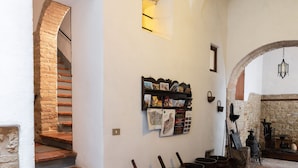 A rustic interior with a brick staircase, a wooden door, and a stone wall. - San Gimignano Apartment in the Heart of the City for 3 People: Fast Wi-Fi, Concierge Service (San Gimignano)