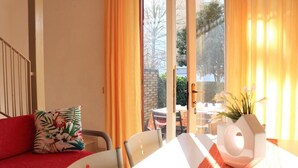 Ein Zimmer mit einem Bett, einem Tisch und einem Fenster mit Vorhängen.