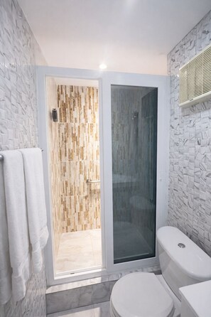 Combinació de dutxa i banyera, tovalloles, sabó i paper higiènic 