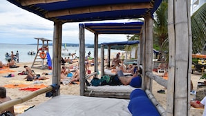 Une plage dotée d’une structure en bambou qui offre de l’ombre.