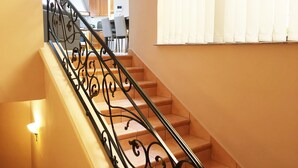 A staircase with ornate black railings leading to a landing.