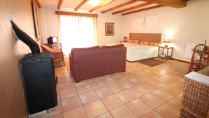 A cozy room with a bed, a sofa, a table, and a fireplace. - Quinta do Pântano is a calm and reserved place, with unique ambience and landscapes (Machico)
